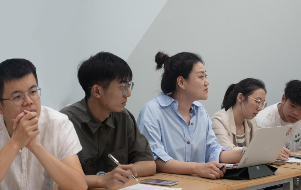 一群人坐在电脑前描述已自动生成